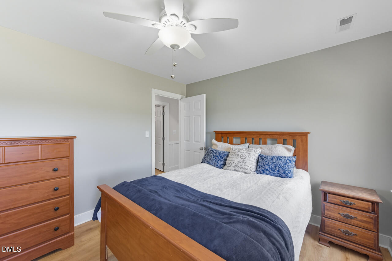 8713 Mourning Dove Road Raleigh, NC 27615 - Photo 31 of 56 a bedroom with a large bed and a chandelier