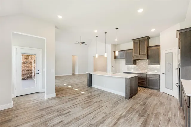 a large kitchen with a wooden floor and stainless steel appliances