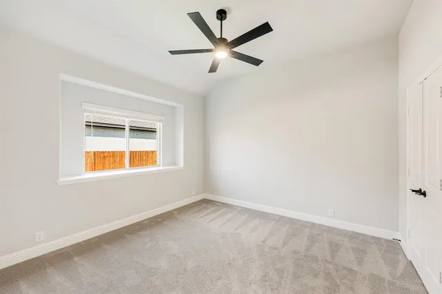 an empty room with closet and ceiling fan