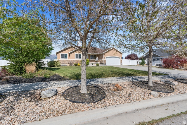 Ranch-style exterior with a two-car garage and a stone facade accent