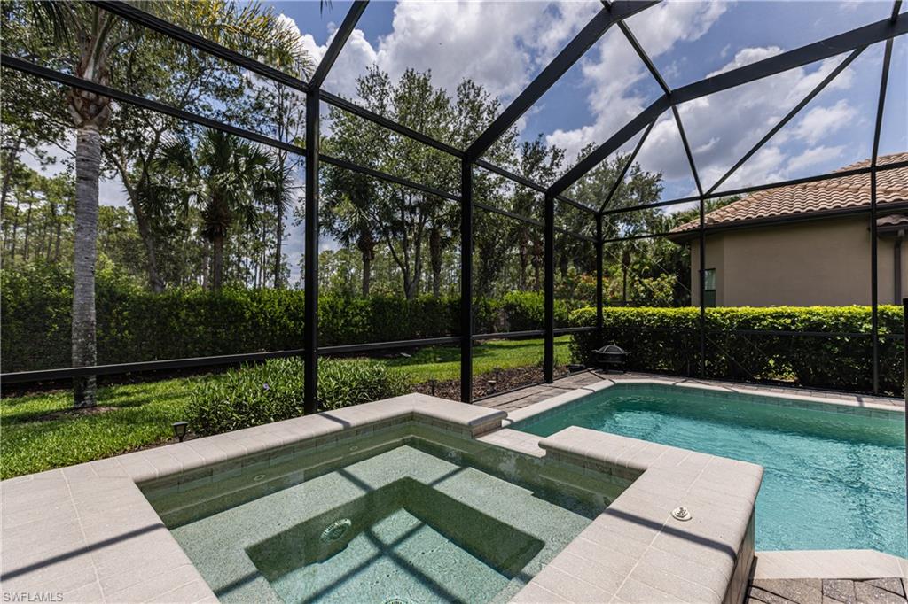 7307 Acorn Way Naples, FL 34119 - Photo 18 of 22 View of pool with a lanai, a sunroom, a pool with connected hot tub, and a patio area