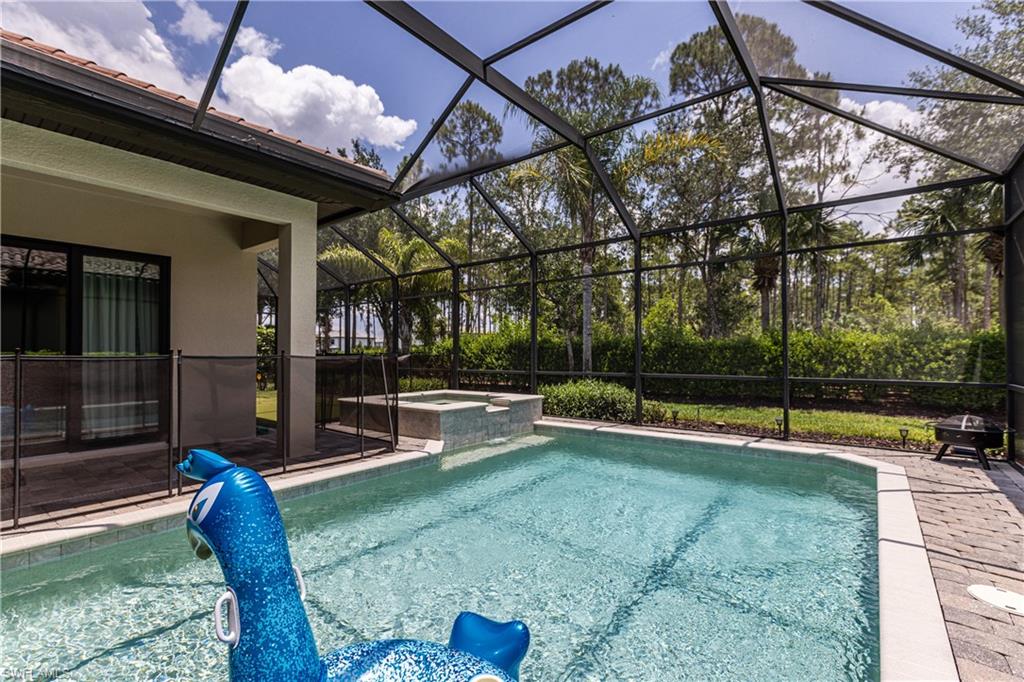 7307 Acorn Way Naples, FL 34119 - Photo 20 of 22 View of pool featuring a sunroom, a lanai, a patio, and a pool with connected hot tub