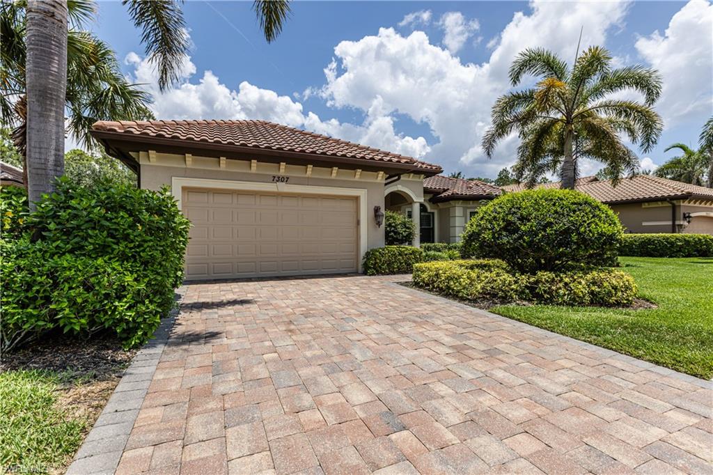 7307 Acorn Way Naples, FL 34119 - Photo 2 of 22 Mediterranean / spanish-style home featuring stucco siding, decorative driveway, an attached garage, and a tiled roof