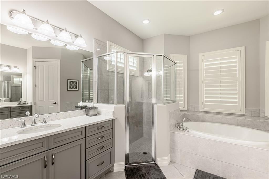 7307 Acorn Way Naples, FL 34119 - Photo 10 of 22 Bathroom featuring vanity, a stall shower, a bath, and light tile patterned floors