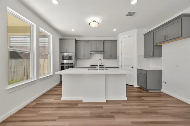 a white kitchen with wooden floor and floors