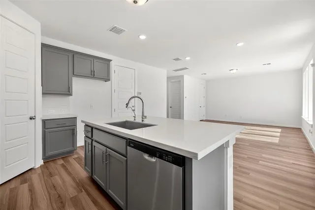 a kitchen with a sink cabinets and wooden floor