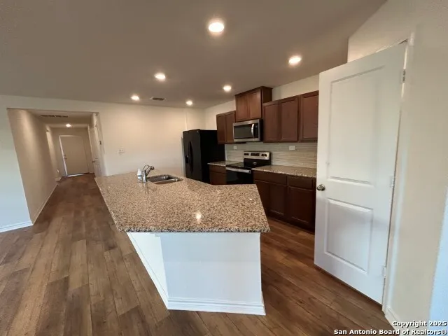 a large kitchen with kitchen island a sink stainless steel appliances and a counter top
