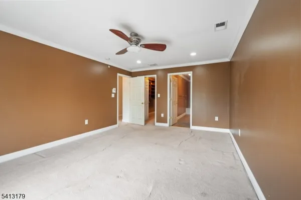 an empty room with ceiling fan and window