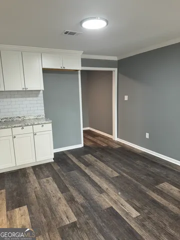 a view of a kitchen with wooden floor and cabinets