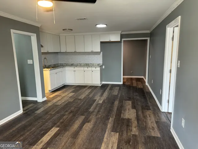 a kitchen with wooden floors and white appliances