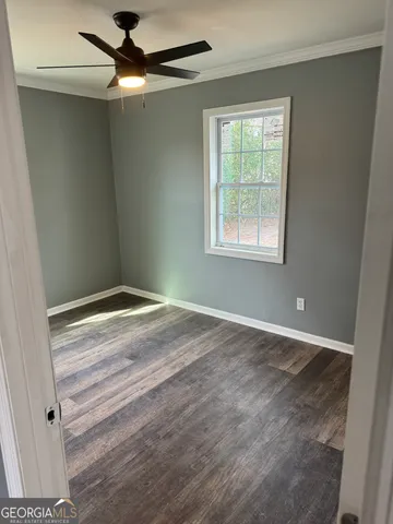 a view of a livingroom with a ceiling fan and window