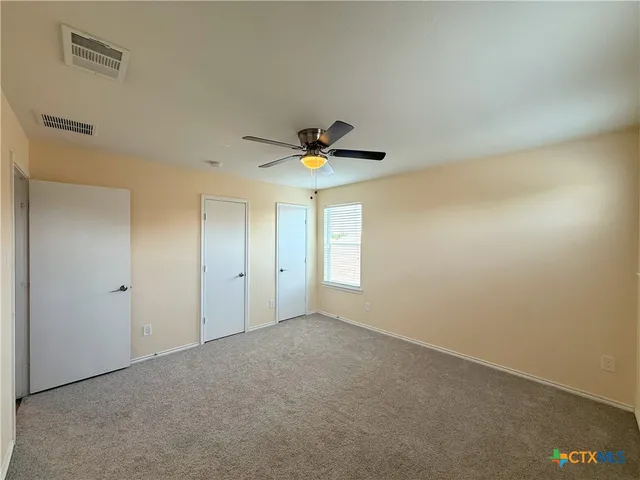 a view of empty room with ceiling fan