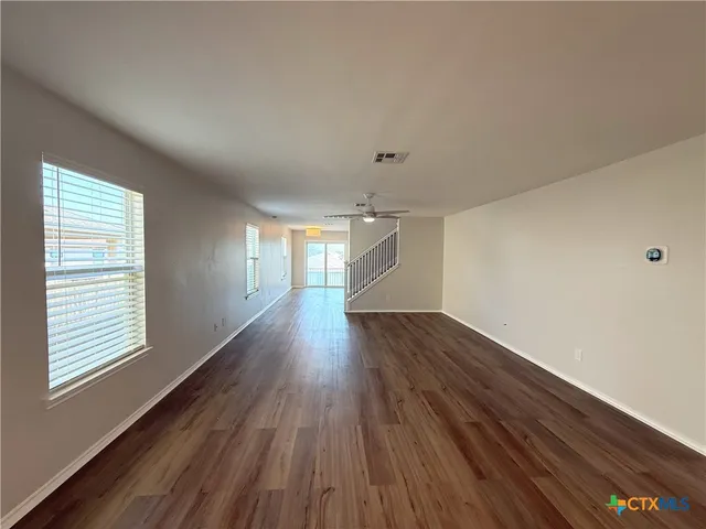 wooden floor in an empty room with a window