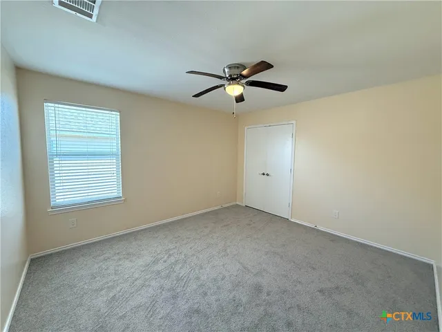 a view of empty room with ceiling fan