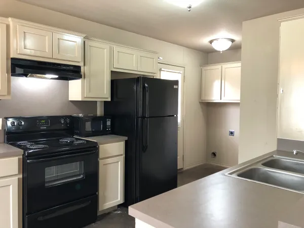 a kitchen with a refrigerator stove and cabinets