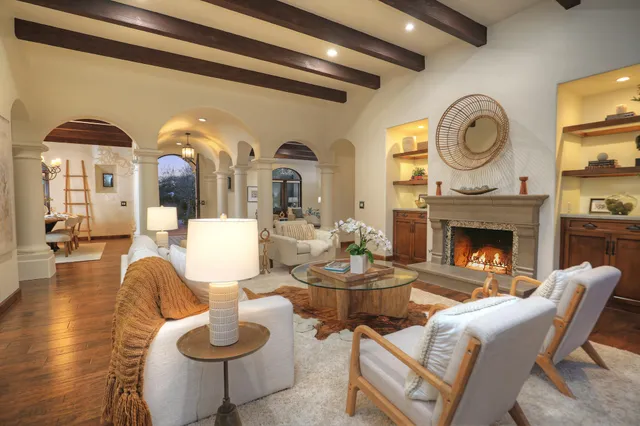 a living room with fireplace furniture and a large window