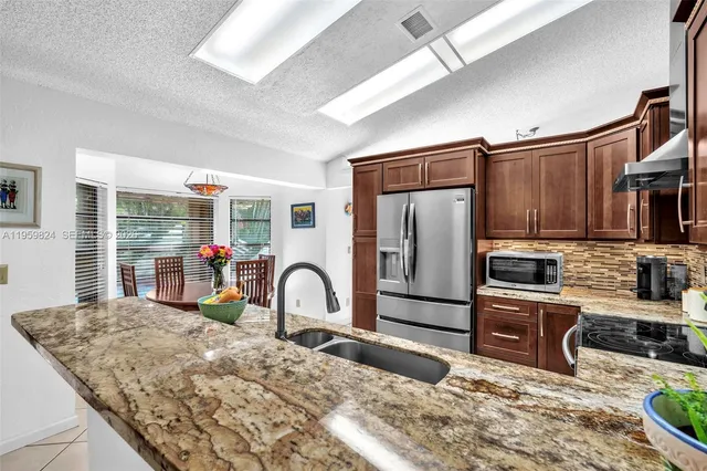 a kitchen with sink refrigerator and stove
