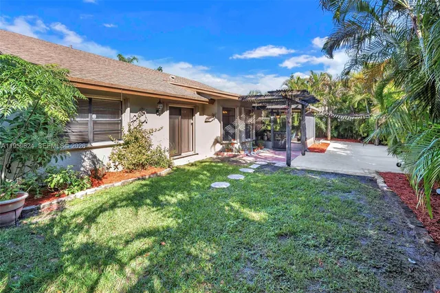 a view of a backyard with plants and a patio