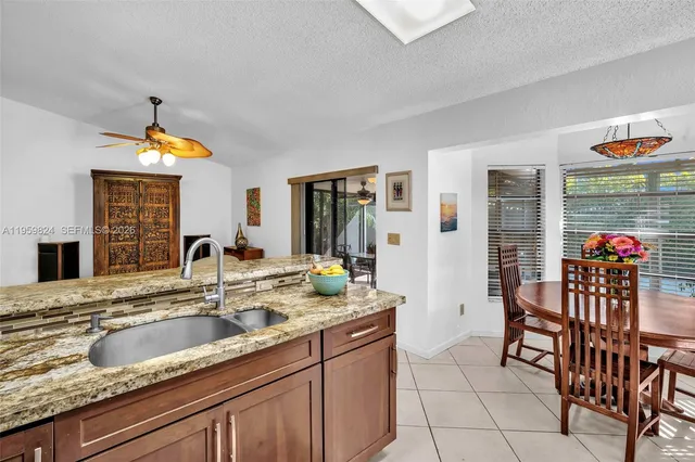 a en suite bathroom with a granite countertop sink and a large mirror