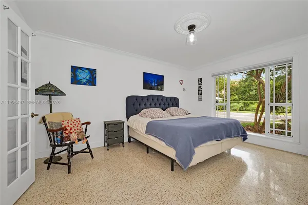 a bedroom with a bed chair and a window