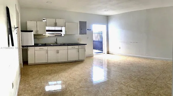 a kitchen with stainless steel appliances a sink a stove a microwave a refrigerator a counter top space and cabinets