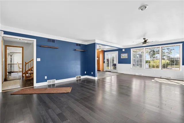 an empty room with wooden floor and fireplace