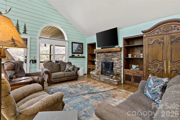 a living room with furniture a flat screen tv and a fireplace