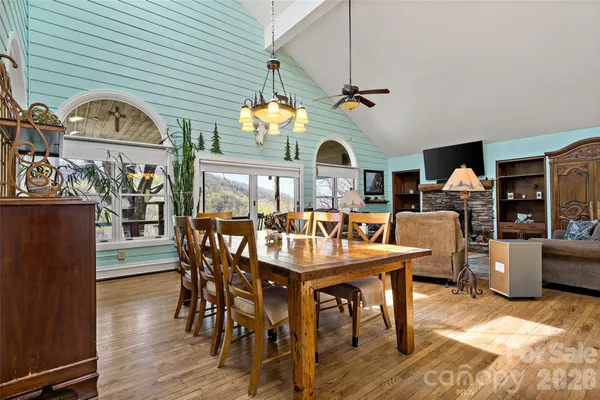 a dining room with furniture a chandelier and wooden floor