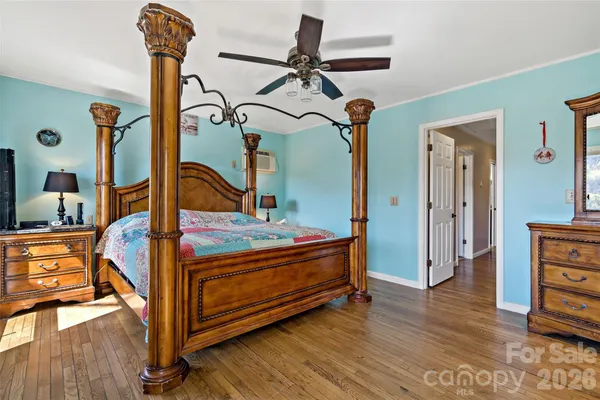 a bedroom with a bed a chandelier and dresser