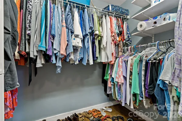 a view of walk in closet with clothes