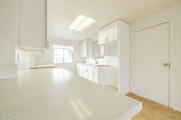 a kitchen with white cabinets and white appliances