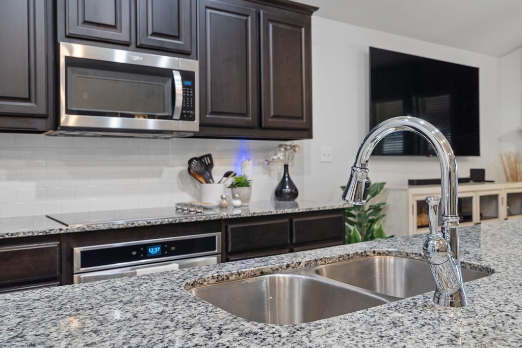 3724 Ranchers Ridge Krum, TX 76249 - Photo 10 of 32 a kitchen with granite countertop a sink and a stove top oven