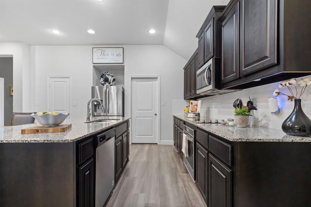 3724 Ranchers Ridge Krum, TX 76249 - Photo 11 of 32 a kitchen with granite countertop lots of counter top space space and stainless steel appliances