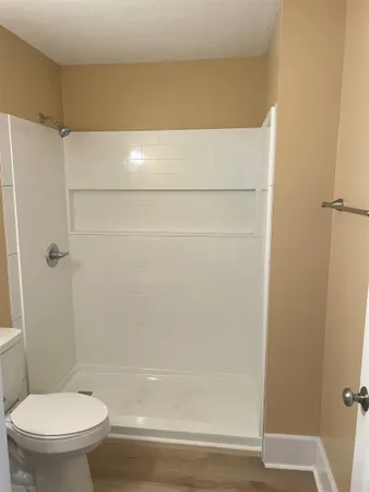 a bathroom with a toilet and a shower