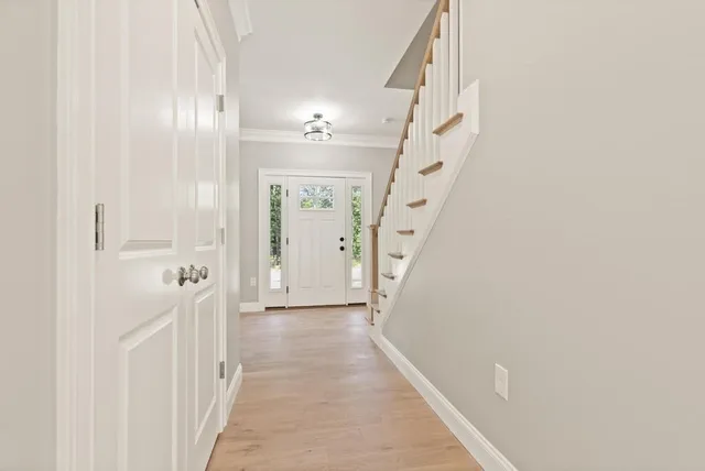 a view of a hallway with wooden floor and entryway