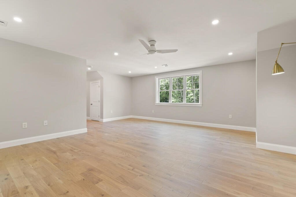 15 Lawler Lane Stoughton, MA 02072 - Photo 27 of 41 an empty room with wooden floor ceiling fan and windows