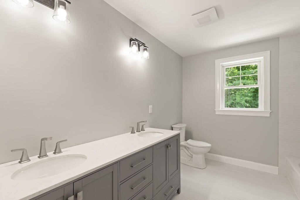 15 Lawler Lane Stoughton, MA 02072 - Photo 34 of 41 a bathroom with a double vanity sink a toilet and a window