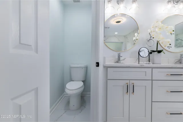 a bathroom with a toilet sink and mirror