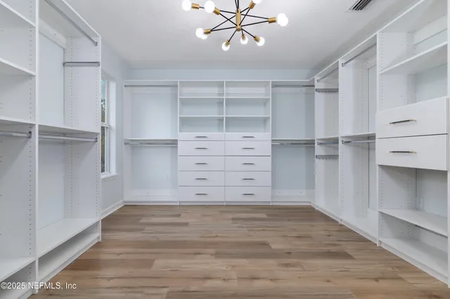 a view of walk in closet with empty racks