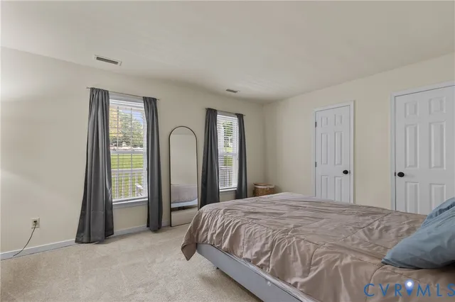 a spacious bedroom with a bed and a window