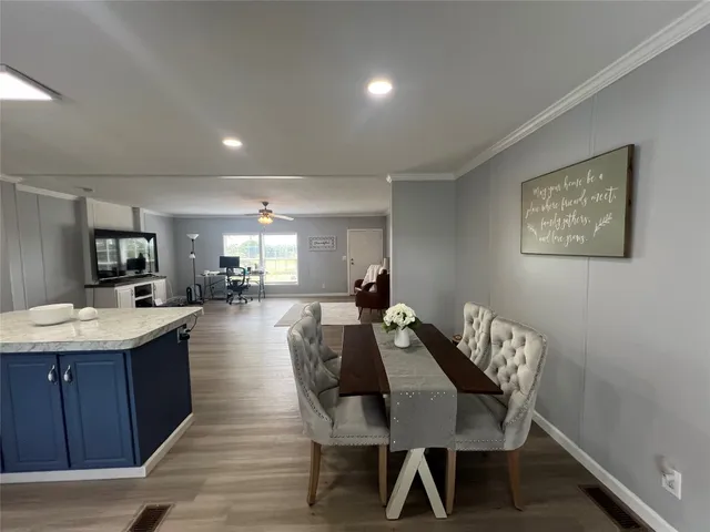 a large living room with stainless steel appliances wooden floor and a view of kitchen