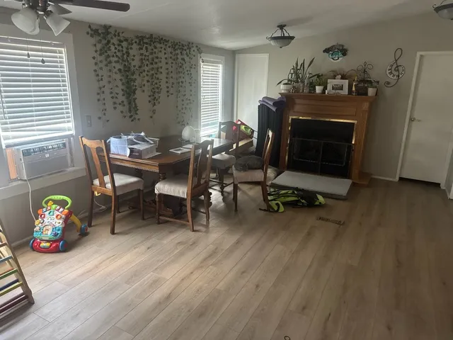 a view of an empty room with window and wooden floor
