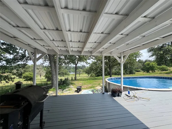 a view of swimming pool with garden and patio