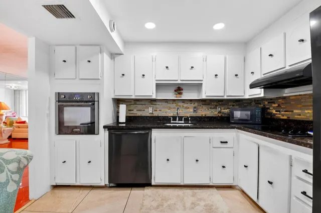 a kitchen with stainless steel appliances granite countertop a sink dishwasher and a refrigerator