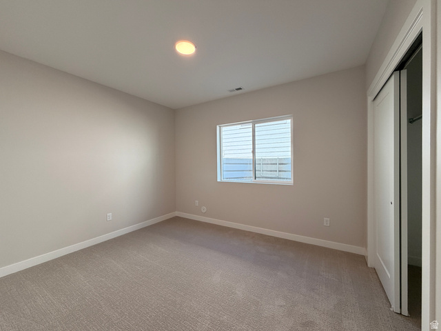 539 East Rimrock Lane Heber City, UT 84032 - Photo 12 of 13 Neutral-toned room featuring a single window with horizontal blinds, light tan carpeting, and a flush-mount ceiling light