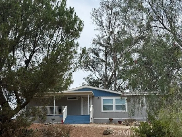 a front view of house with yard and trees around
