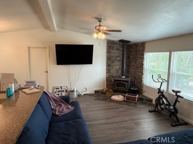 a living room with furniture a flat screen tv and a large window