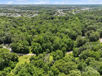 an aerial view of residential houses with outdoor space and trees
