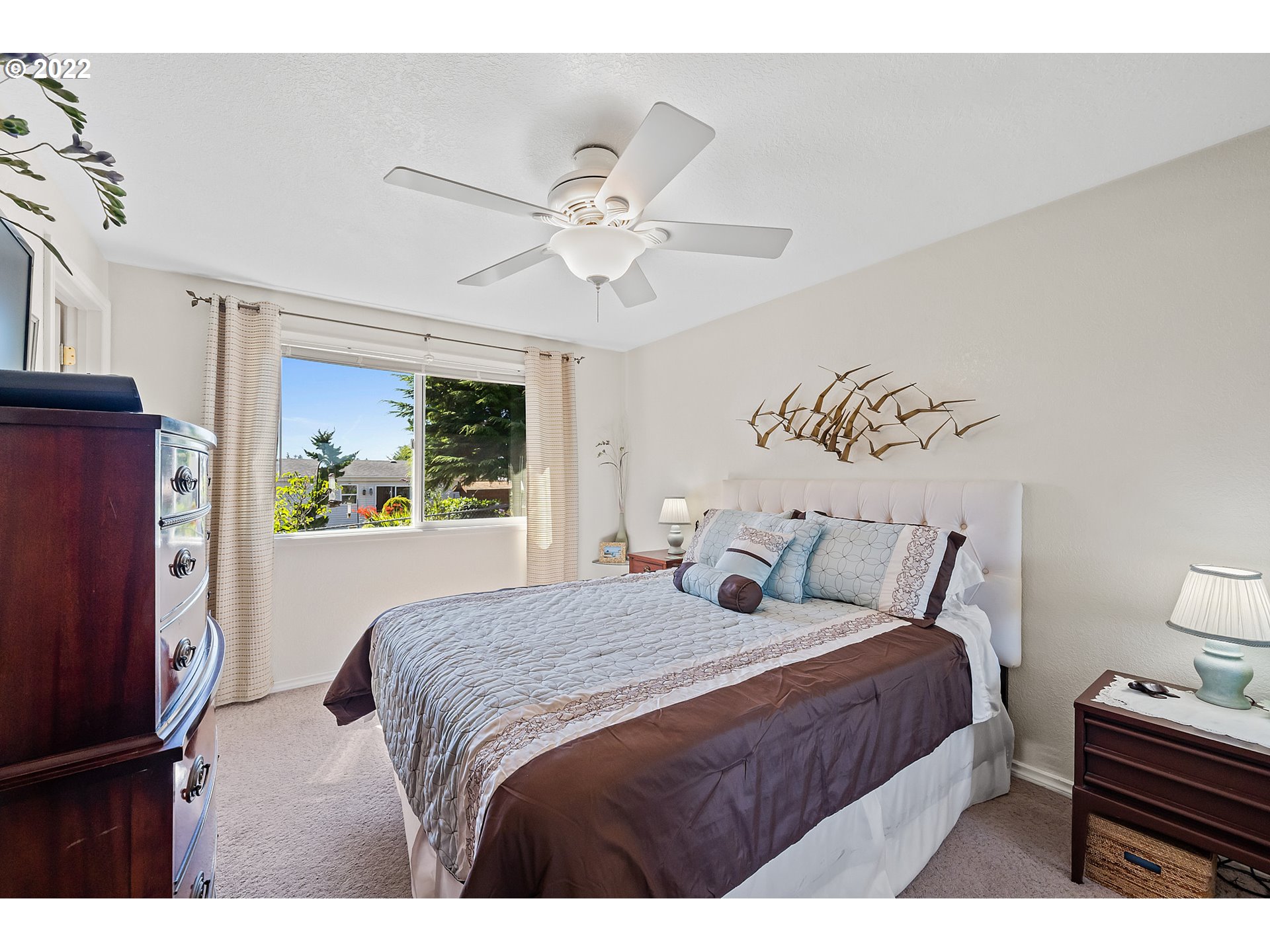 4225 Orchard Loop Netarts, OR 97141 - Photo 15 of 31 a bedroom with a large bed and a chandelier