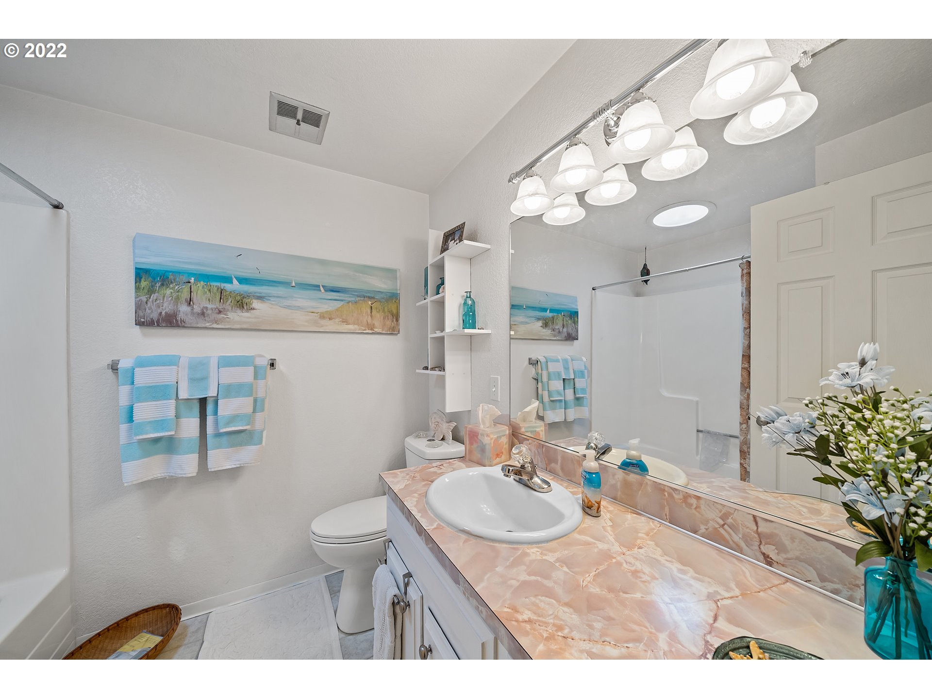 4225 Orchard Loop Netarts, OR 97141 - Photo 17 of 31 a bathroom with a sink a toilet and a mirror